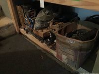 Shelf with cardboard boxes containing various sockets, ratchets, screwdrivers, pipe wrenches and possibly other hand tools.