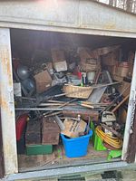 General shed interior showing assorted toolboxes, garden tools, basket and coiled hose