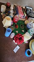 Wide view of assortment featuring candles of various types and candle holders on a tabletop.