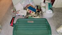 Closed green plastic storage tote with label 'Fabrics and Filling'