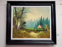 Overall view of framed oil painting showing cottage, road, trees and signature in black frame with white matting.