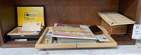 Overview of the lot with multiple stamp albums and sleeves arranged on a wooden shelf, showing some postal covers and vintage cards included.
