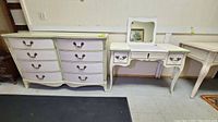 Full view of pastel shabby chic French Provincial style dresser and lift-top mirrored vanity dressing table side by side on tile floor