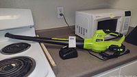 Full view of the Snap Fresh electric leaf blower with attached battery and charger cable on kitchen counter.
