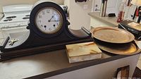 Vintage New Haven mantle clock, two silverplate trays, and onyx lidded box on kitchen counter
