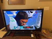 Sharp Aquos 44-inch flat screen TV displaying sports channel with visible Sharp logo.