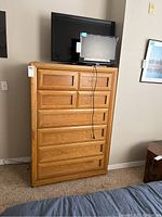 Full view of the Thomasville dresser, showing its six drawers and wood finish. Two screens are placed on top, not included.