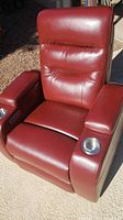 Front view of red faux leather recliner showing headrest, lumbar area and cupholders