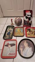 Full lot layout: 6 Coca-Cola vintage trays, bowling ball, animated polar bear in box.