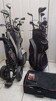 Two full golf bags with clubs, push cart and accessory case arranged on tile floor