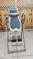 Front angle showing full view of inversion table, padded backrest, foot rests, and frame.