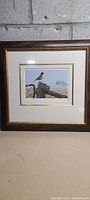 Framed art print of a bird perched on a wooden fence post with countryside background.