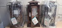 Front view of 3 Martha Stewart brand LED lanterns with nature design on glass panels, still in plastic wrapping.