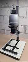 Full view of the vintage Fujimoto photo enlarger showing the baseboard, vertical column, and lens assembly.