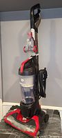 Full view of Dirt Devil upright vacuum showing handle, dust canister and base.