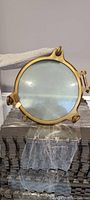 Full front view of brass porthole on foam padding