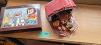 The closed cube box with cartoon lion and other characters on the lid, octagonal shape with red edges visible.