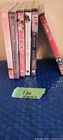 Spine view of six unopened DVD cases showing titles.
