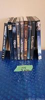 Photo of 9 DVDs standing side by side showing titles on case spines