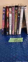 Eight DVD cases standing upright showing the spine titles of each movie including Hollywood Homicide, Knowing, Behind the Mask, Dirty Dancing, Indiana Jones and the Kingdom of the Crystal Skull, The Haunting, Jane Eyre, and The Water Horse.