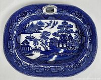 Full top view of rectangular antique blue and white William and Mary style advertising platter with Blue Willow pattern by James Green & Nephew.
