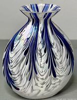 View of blue and white art glass vase showing feather design and rounded shape