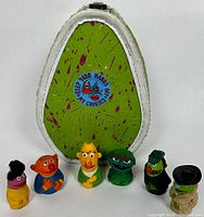 Set of six sesame street finger puppets with carrying case; puppets standing upright in front of case displaying cookie graphic.