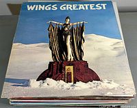 Top view of the stack showing the album cover Wings Greatest featuring a statue figure on a snowy base.