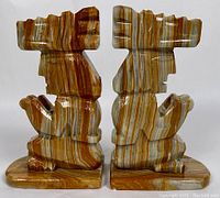 Front and back view of the pair of carved marble bookends with Aztec design, showing the detailed striations and polished surfaces