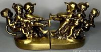 Side view of the brass bookends showing children and dog figures engaged in a tug of war