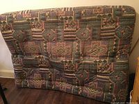 Full view of the front side of the futon mattress showing the colorful geometric fabric pattern and tufted design.