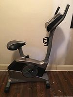 View of the full HealthRider H10X exercise bike showing the seat, pedals, handlebars, and base on a wooden floor.