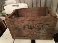 Front view of vintage wooden 7-Up crate showing faded green logo and text 'Fresh Up with 7up Family Size SEVEN-UP'.