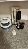 Cuisinart hand blender, electric carving knife mounted with wall holder, and Black & Decker electric jar opener on kitchen counter.