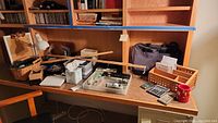 Overview of desk with various office supplies including wooden organizers, calculators, scissors, a desk lamp, and other office tools