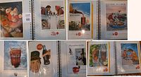 Photo of an open album displaying multiple Coca Cola advertisements from 1950s-60s, showing various themed ads including Santa Claus, service station, outdoor picnics, and bottle-focused images.