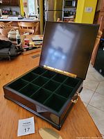Open tea chest showing 12 green felt-lined compartments inside for storing tea bags.