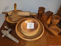Photo showing the entire lot including bowls, rolling pin, butter pat, salad bowl with server, barrel tap, and carved bookends.