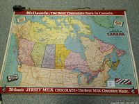 Full view of the vintage wall map showing Canada and surrounding areas with a red border advertising Neilson's Chocolate bars, including Jersey Milk Chocolate.