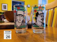 Pair of vintage promotional glasses featuring Tom Henke and Lloyd Moseby with full-color team and sponsor details