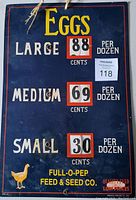 Front view of vintage advertising store display sign showing egg prices for large, medium, and small eggs per dozen, with adjustable price wheels.