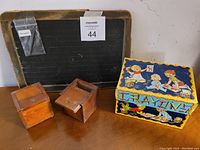 Photo showing the full set: slate chalkboard with pencil, two wooden boxes, and crayons tin.