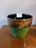 Full top-side view of the ceramic jardiniere showing brown and green glaze with leaf design and wide open top