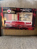 Boxed Texico Eaglet model airplane seen from front, showing red and white paint, Texaco logo, and clear window on the display box.