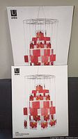 Two Umbra Vine Photo Organizers in factory packaging, displayed stacked one on top of the other with visible product images and branding on the boxes.