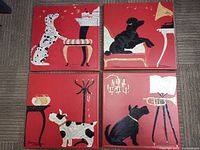 Four red vinyl prints with dog illustrations arranged in a 2x2 grid.