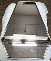Full front view of the rectangular mirror showing the metal frame and shelf at the base.