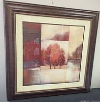 Front view of framed wall art showing autumn tree collage with warm colors and cream matte border.