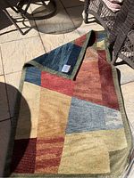 Photo of the rug folded at one end showing the backside and texture of the material under natural light.