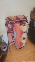 Photo showing metal blanket stand holding folded queen size bedspread and Native American inspired throw draped in front